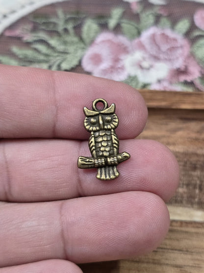Eulen-Charm 20x13mm in Bronze-Optik auf zwei Fingern gehalten als Größenvergleich.