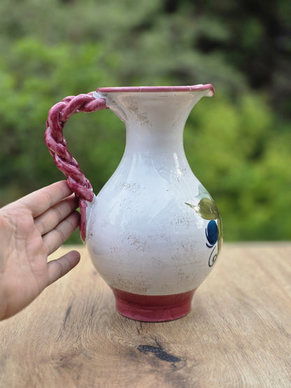 Weißer und roséfarbener Vintage Krug von Fratelli Fanciullacci mit Zopfhenkel, Blumendekor und sichtbarer Reparatur am oberen Rand.