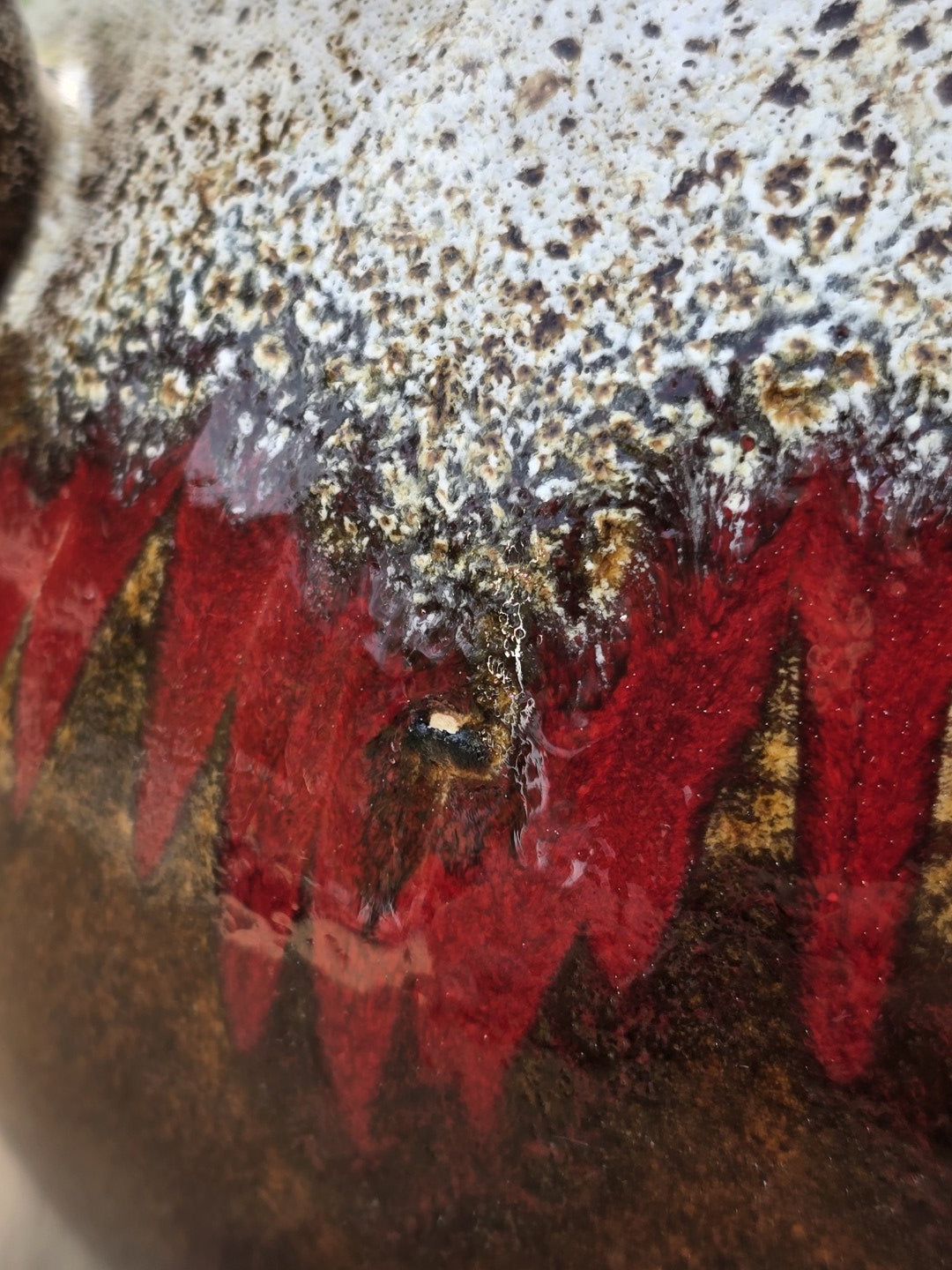 Nahaufnahme der roten Fat-Lava-Effektglasur mit weiß gesprenkelter Oberfläche auf einer West Germany Keramikvase