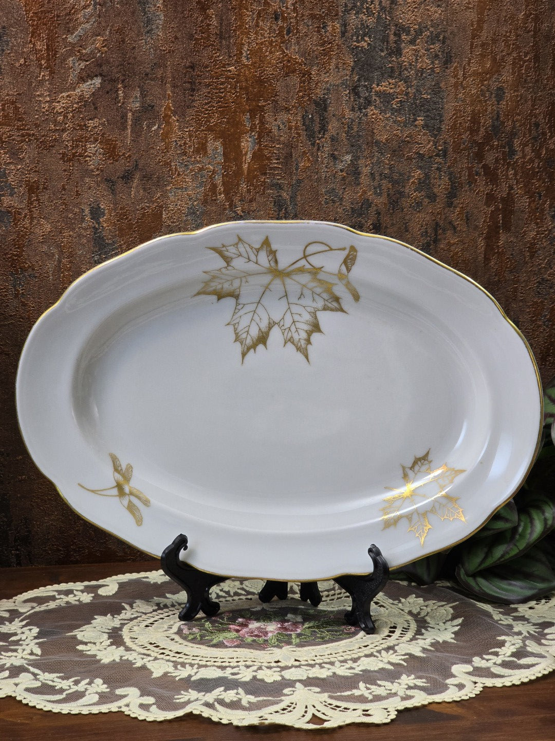 Freiberger Porzellan Servierplatte mit ovaler Form, Goldrand und goldenem Ahornblattdekor auf Spitzenunterlage