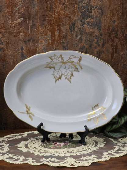 Freiberger Porzellan Servierplatte mit ovaler Form, Goldrand und goldenem Ahornblattdekor auf Spitzenunterlage
