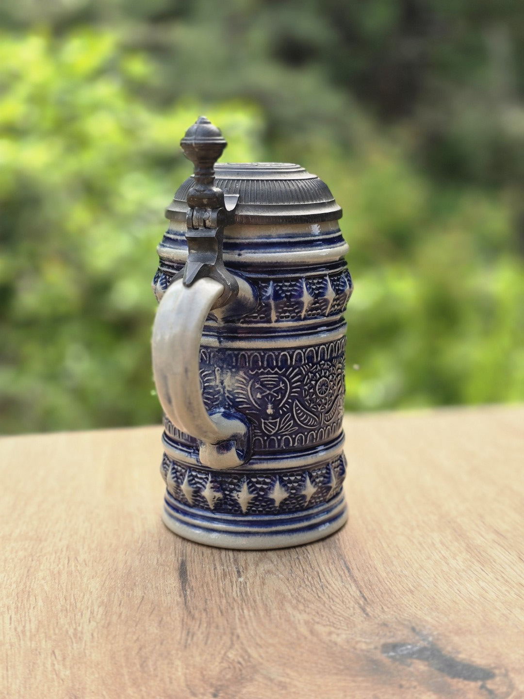 Rückansicht eines Vintage Bierseidels aus Westerwald Steinzeug mit Reliefdekor und Metallbeschlag