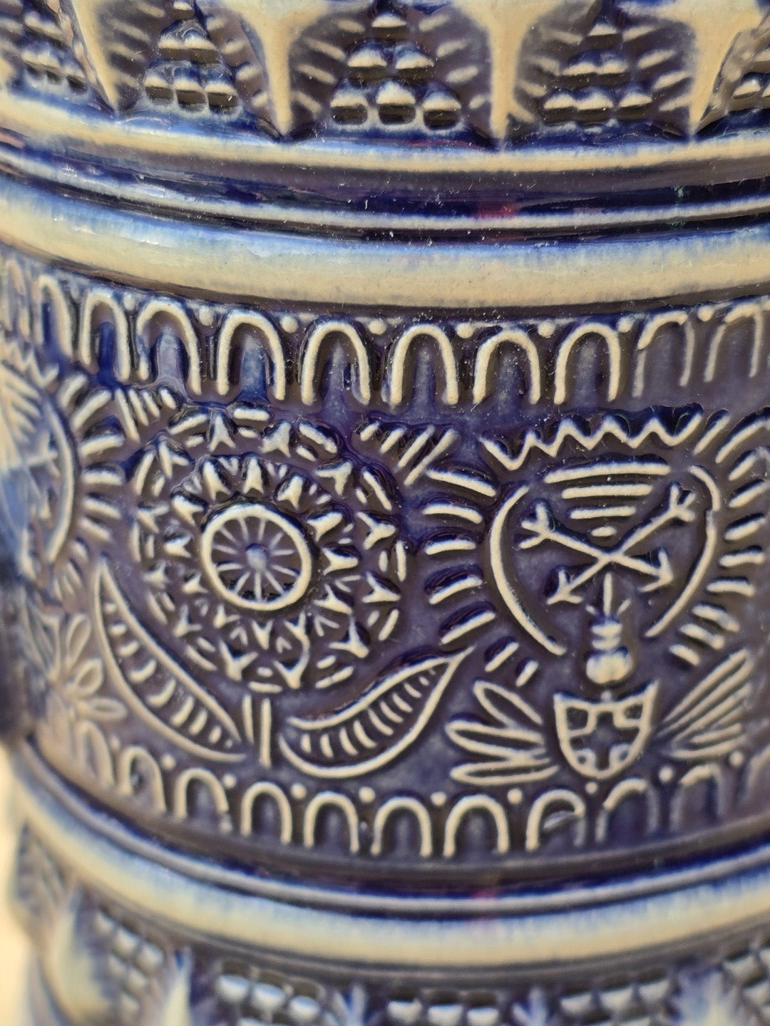 Detail des kobaltblauen Reliefdekors mit floralen Ornamenten und Wappenmotiv auf Steinzeug