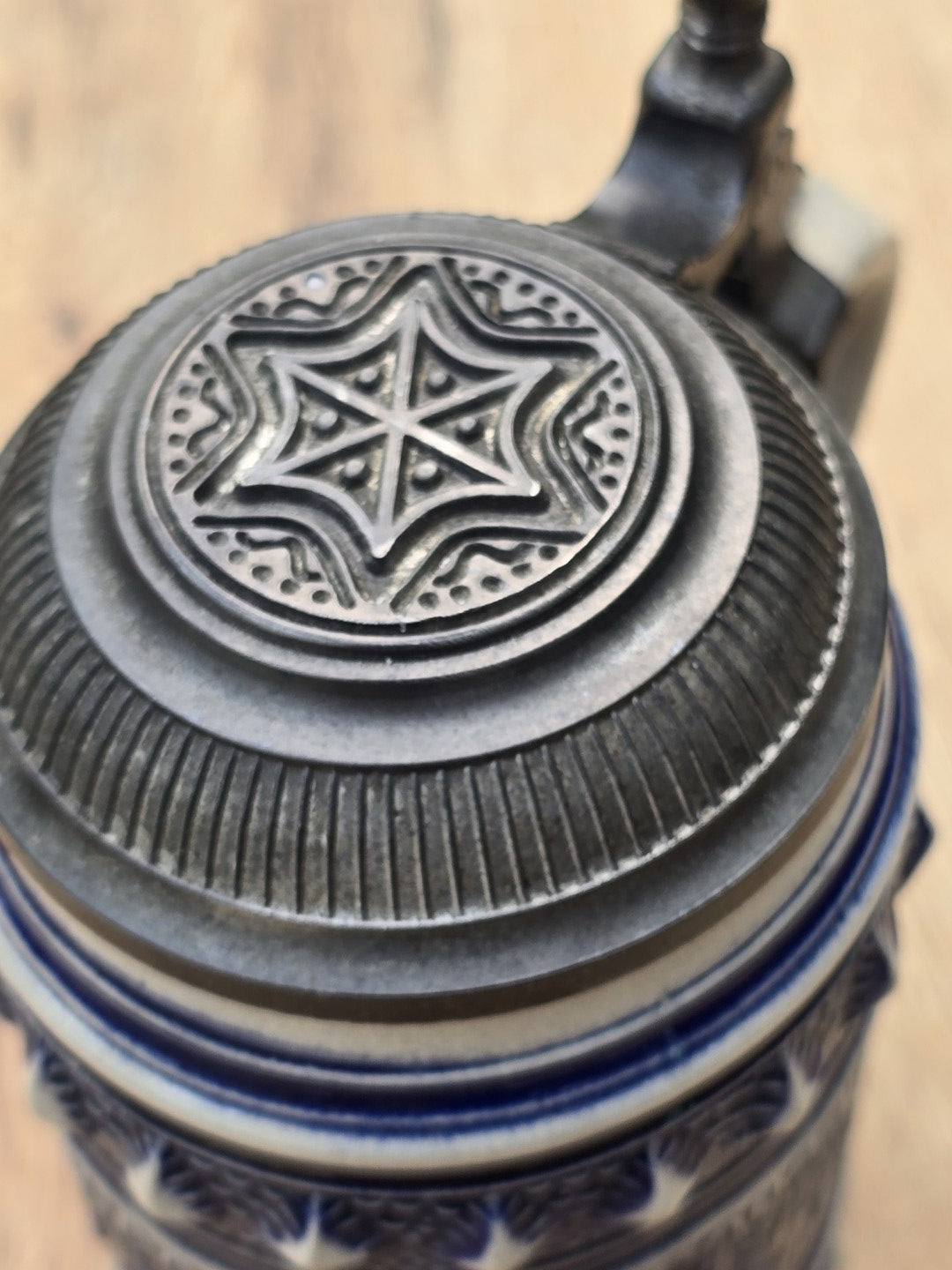 Geprägter Zinndeckel eines Vintage Bierseidels mit Sternornament und geriffeltem Rand