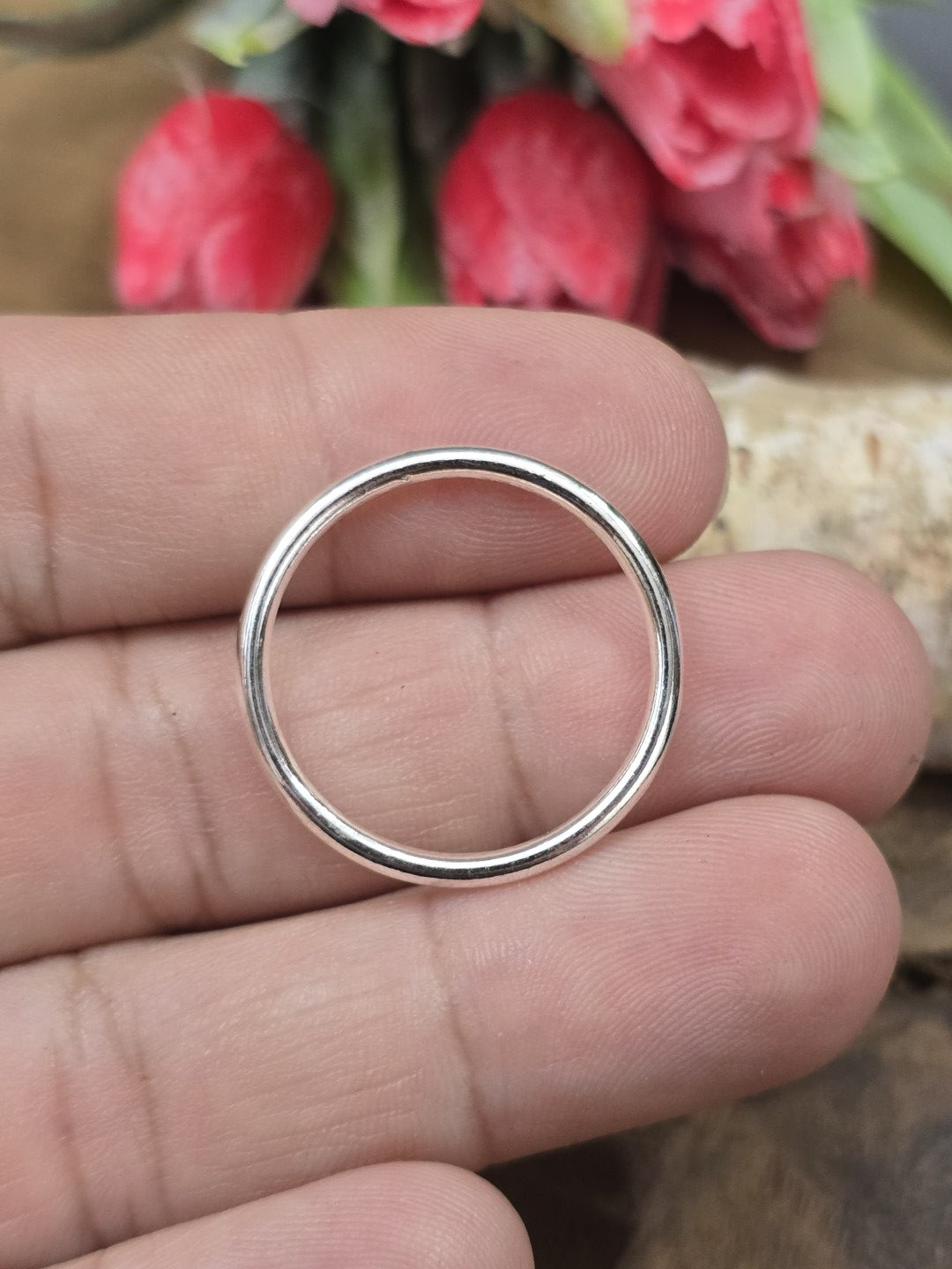 Ein silberfarbener geschlossener Verbindungsring auf einer Hand präsentiert zur Veranschaulichung der Größe von 24 mm für DIY-Projekte.