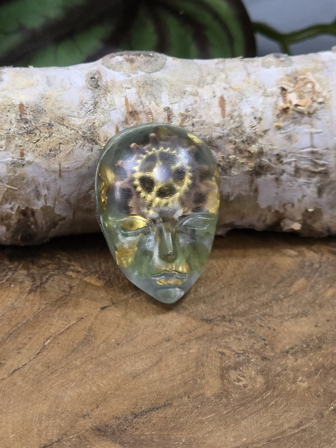 Großer grüner Resin-Cabochon mit Gesichtsmotiv, Zahnrädern und goldfarbenen Steampunk-Details