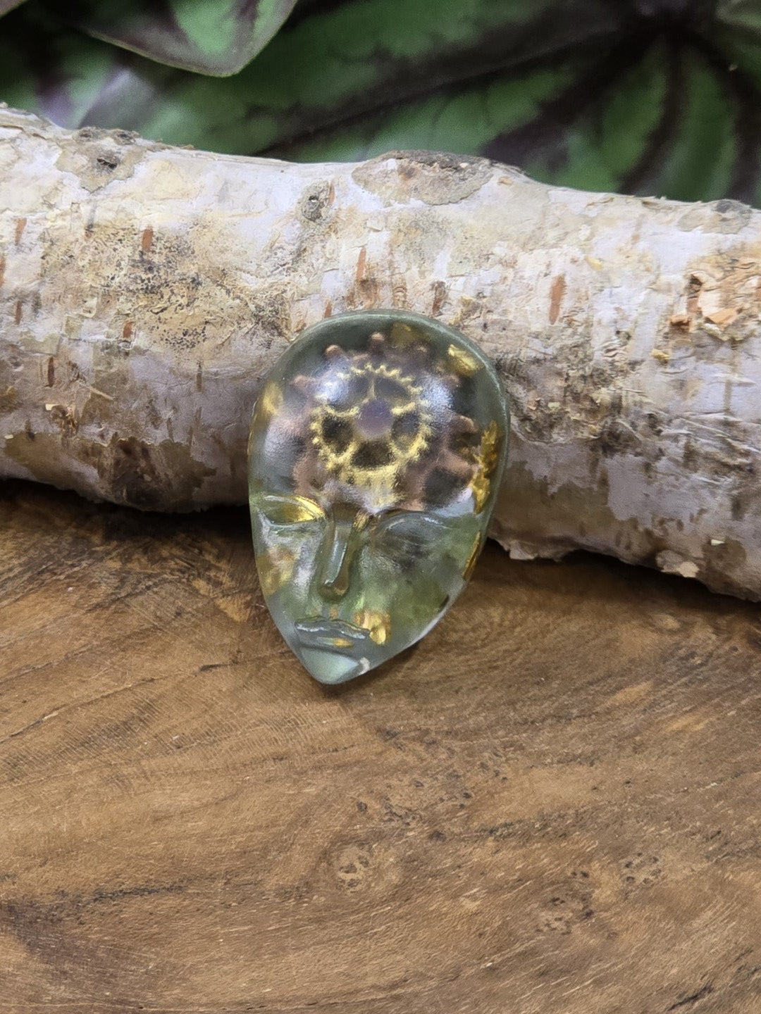 Handgefertigter Unikat-Cabochon mit maskenartigem Gesicht, grünem Resin und Zahnrädern