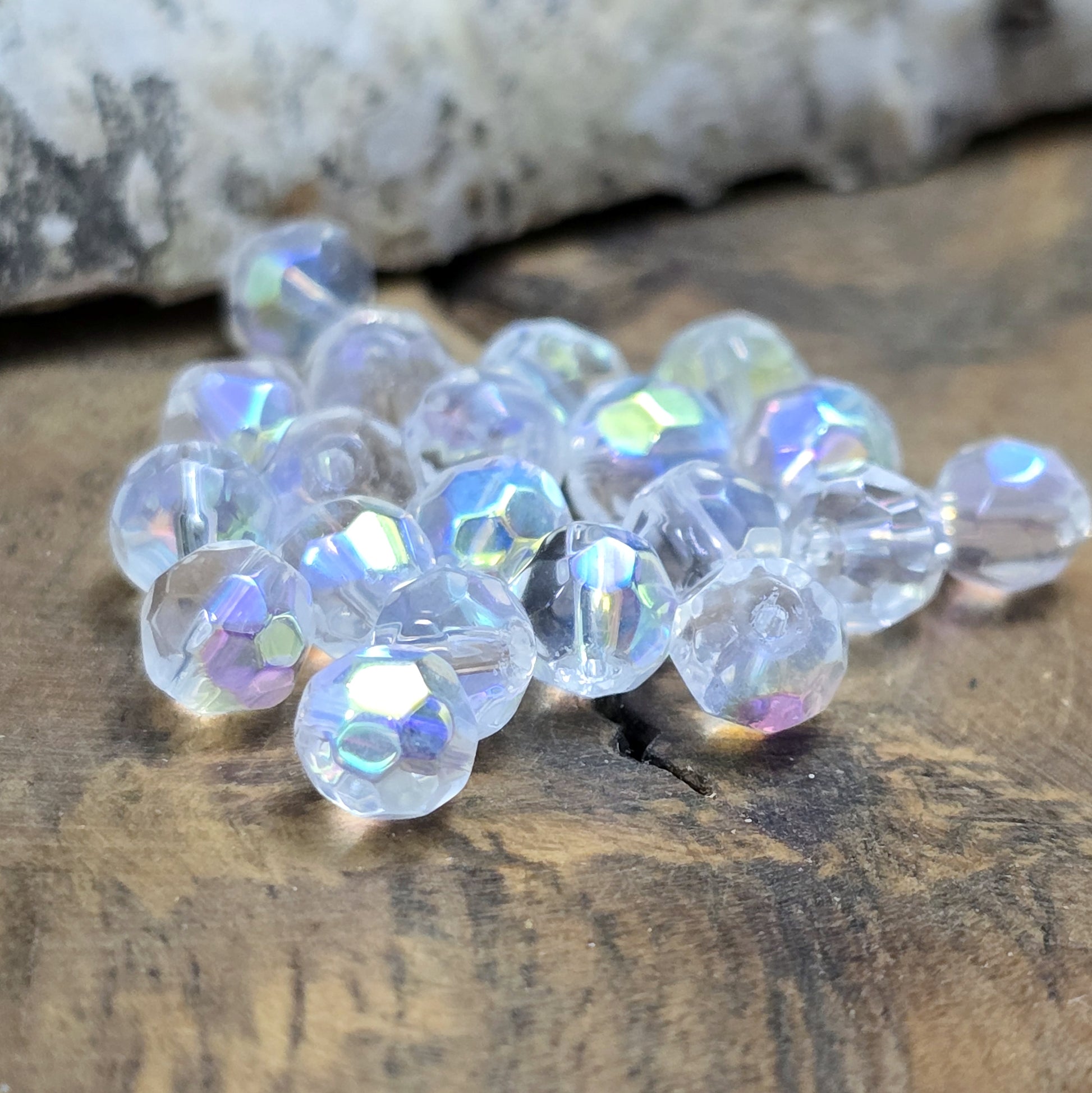 Das Bild zeigt 40 kleine facettierte Glasperlen – Kugel – 6mm – Crystal AB – Funkelnde Eleganz für deine Schmuckkreationen