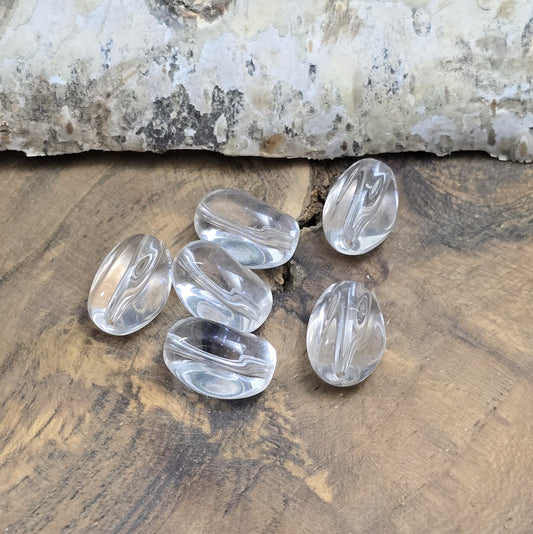 Das Bild zeigt Glasperlen in Nuggetform, farblos transparent. 13mm