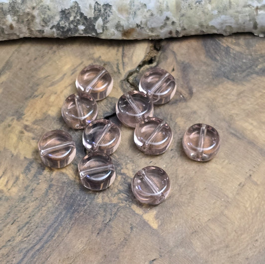 Das Bild zeigt kleine münzförmige Glasperlen in der Farbe Amethyst, für die individuelle Schmuckherstellung.