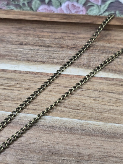 Nahaufnahme der einzelnen Kettenglieder der antiken Bronze-Gliederkette auf Holz.