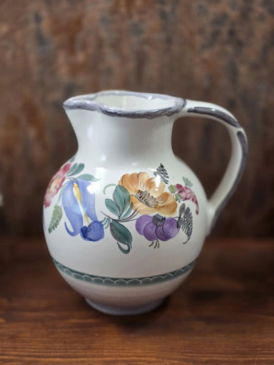 Vintage Keramikkrug mit bauchiger Form, floralem Dekor in Blau, Ocker, Violett und Grün sowie grau gerändertem Ausguss.