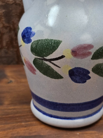 Kleiner DDR-Keramikkrug von Gräfenroda mit blauem Streifendekor, zartem Blumenmuster und heller glasierter Oberfläche.