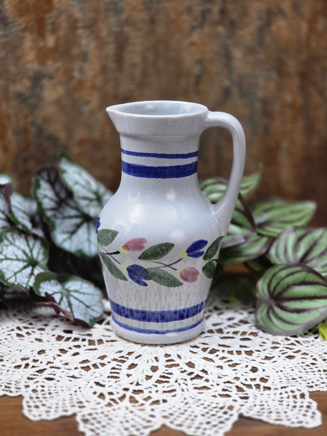 Kleiner Keramik-Zierkrug von Gräfenroda aus DDR-Zeit mit blauem Streifenrand, Blumenband und hellem glasiertem Scherben.