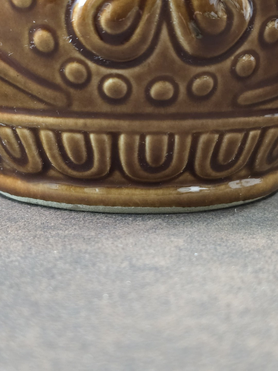 Vintage Keramikbecher mit brauner Glasur, floralem Relief und ornamentalem Abschlussband am unteren Korpus in Nahaufnahme