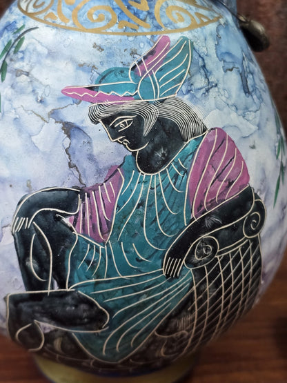Vintage Keramikkanne mit sitzender schwarz konturierter Figur in türkisfarbenem Gewand und rosa Ärmeln in Nahaufnahme