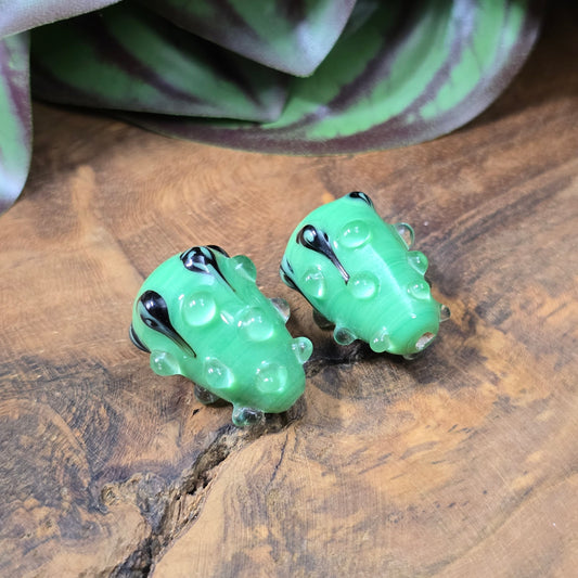 2 handgefertigte Lampwork-Glasperlen in Tropfenform, grün mit schwarzem Dekor. Einzigartiges Material mit Noppen für kreative Schmuckherstellung.