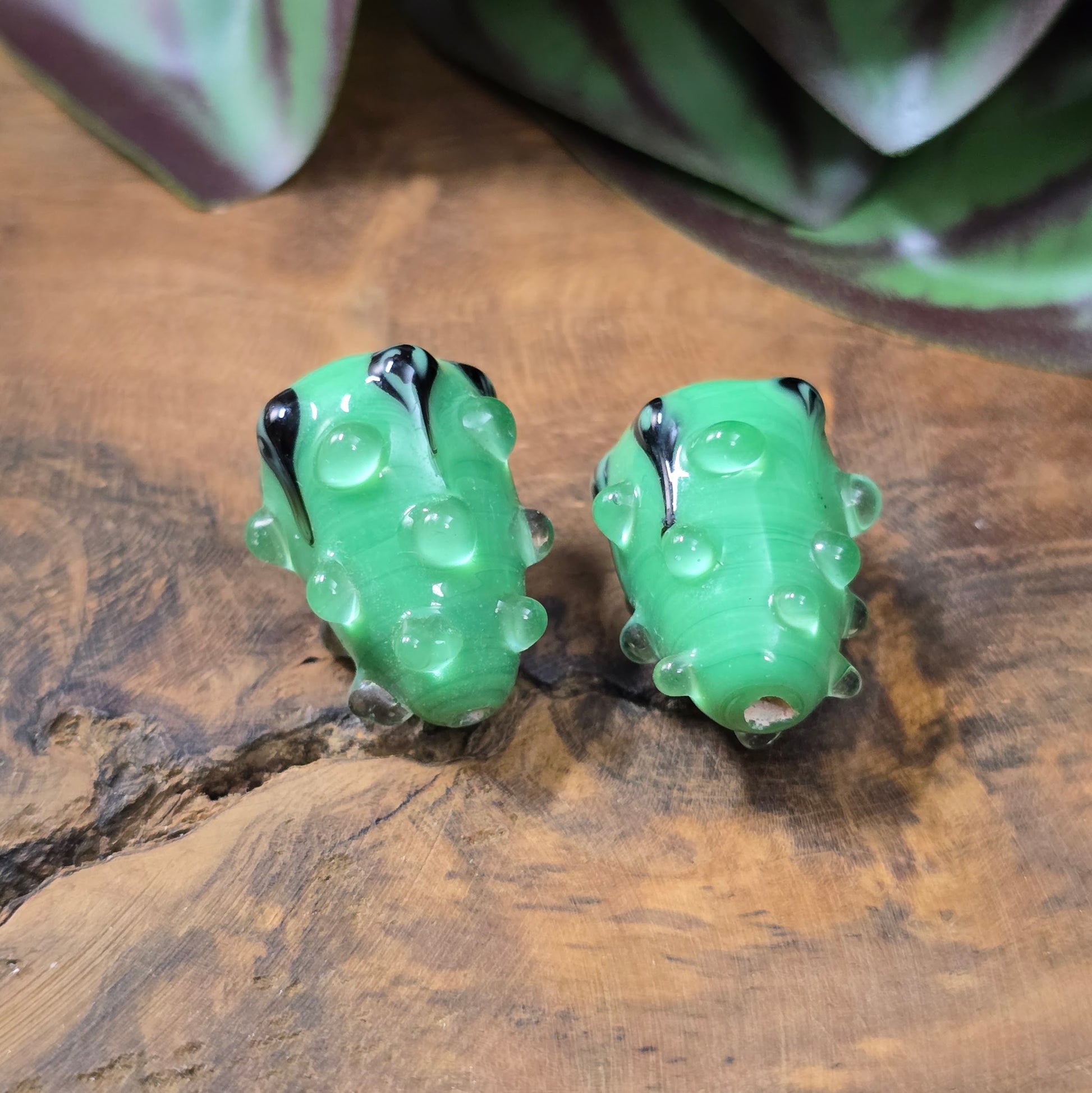 2 handgefertigte Lampwork-Glasperlen in Tropfenform, grün mit schwarzem Dekor. Einzigartiges Material mit Noppen für kreative Schmuckherstellung.
