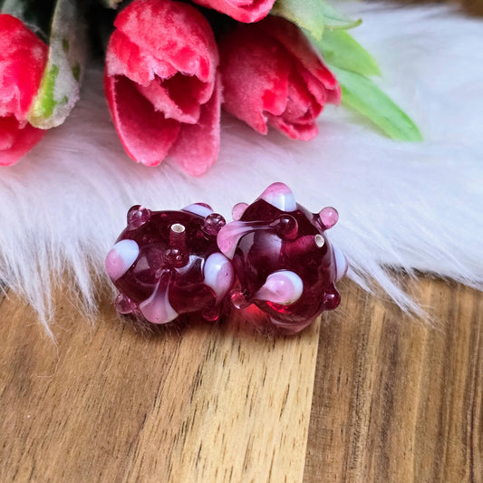 2 handgefertigte indische Glasperlen in Beere mit rosa-weißen Bumps. Perfekt für auffällige Ketten, Armbänder und individuelle Schmuckdesigns. Unikate mit Charme.