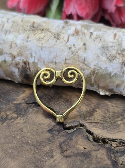 Ein einzelner goldfarbener Herz-Perlenrahmen (21 mm) hochkant aufgestellt vor Birkenrinde auf einer rustikalen Holzscheibe.