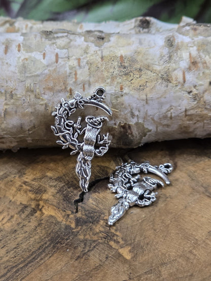 Detailansicht von zwei Hexen-Mond-Charm-Anhängern aus Metall auf Holzplatte