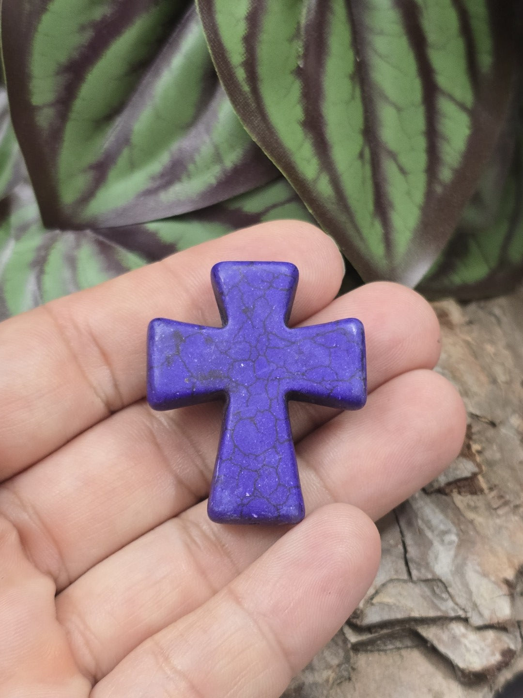 Lila Howlith Kreuzperle (36 mm) auf einer Hand präsentiert als Größenvergleich für DIY-Schmuckprojekte