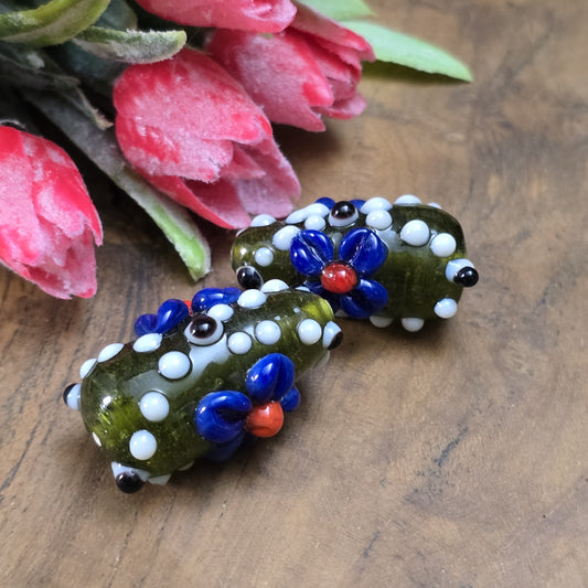 2 Handgemachte indische Glasperlen mit 3D-Blumenmuster in Tropfenform – Dunkelgrün/Blau/Weiß

Diese zauberhaften Glasperlen werden in sorgfältiger Handarbeit gefertigt und bestechen durch ihr opulentes 3D-Muster in Form von Dots und Blumen. Jede Perle ist ein Unikat und bringt einen Hauch traditioneller Handwerkskunst in deine Kreationen.