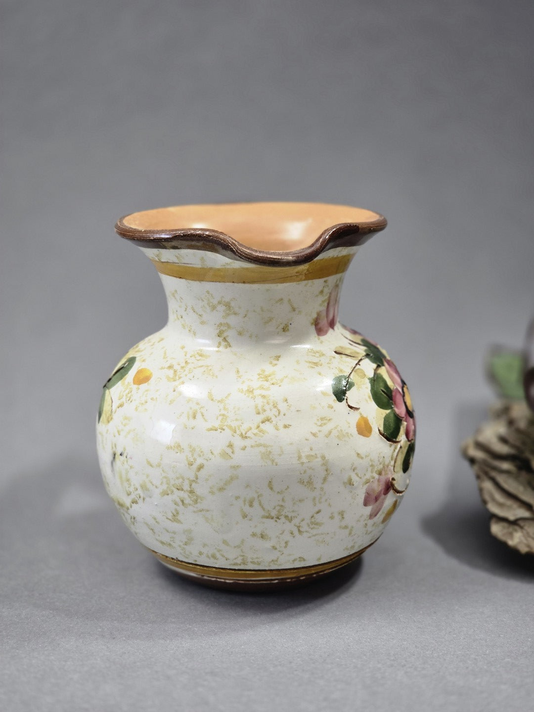 Rückansicht des handbemalten Keramik Krugs mit cremefarbener Glasur, floralen Akzenten, braunem Henkel und Ausgussform
