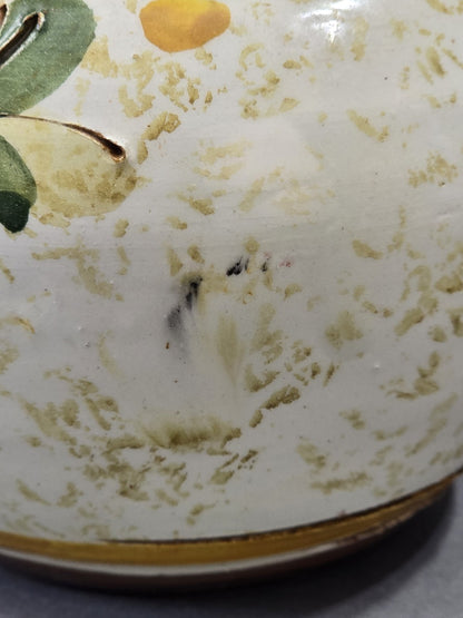 Nahaufnahme kleiner dunkler Gebrauchsspuren auf der hellen Keramikoberfläche des Vintage Blumenkrugs