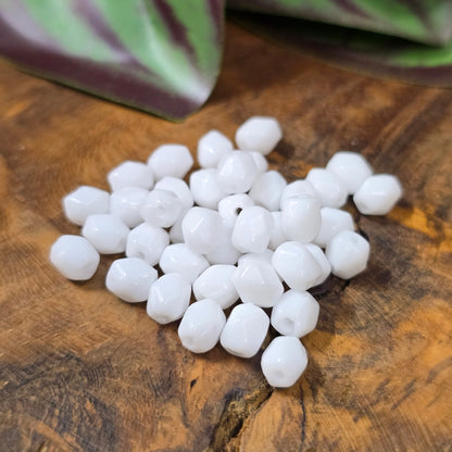 40 klassische Glasperlen in opakem Weiß (5 mm), oval & facettiert – aus Gablonz. Perfekt für elegante DIY-Schmuckideen, gut kombinierbar und vielseitig einsetzbar