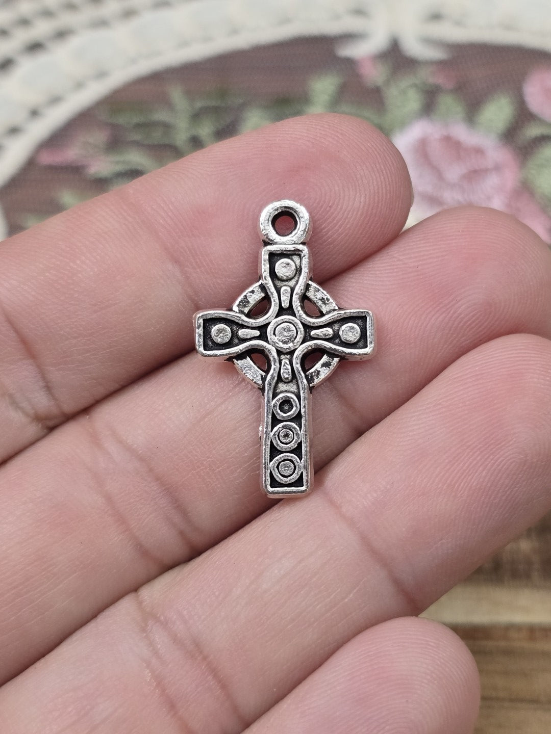 Keltisches Kreuz 26x16mm in Silber-Optik quer auf Hand gehalten als Größenvergleich.
