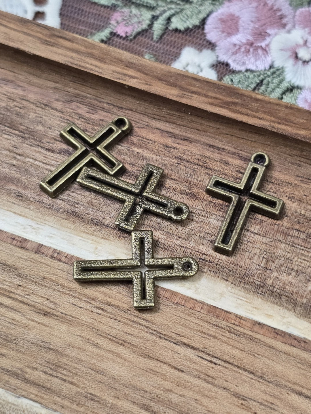 Vorder- und strukturierte Rückseiten der kleinen Kreuz-Anhänger im Vintage-Stil für DIY-Ketten.