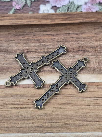 Rückseite von zwei bronze-farbenen Kreuz-Anhängern für DIY-Ketten und Schmuckherstellung.