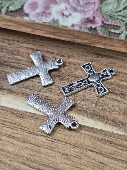 Vorder- und strukturierte Rückseiten der flachen Kreuz-Anhänger im Vintage-Stil für DIY-Ketten.