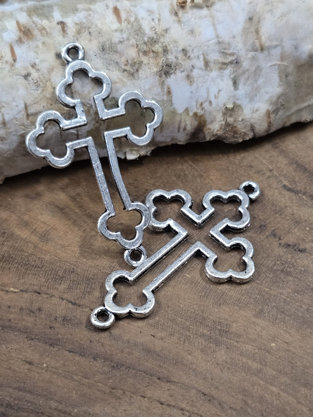 Zwei überkreuzte antike silberne Kreuz-Schmuckverbinder (35 mm) zur Ansicht der Ösen und der feinen Metall-Struktur.