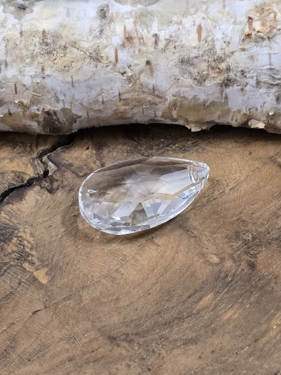 Seitliche Ansicht eines facettierten Kristallglas-Tropfens mit flacher Rückseite