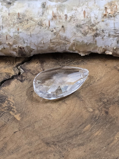Seitliche Ansicht eines facettierten Kristallglas-Tropfens mit flacher Rückseite
