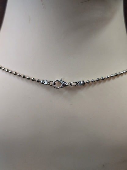 Nahaufnahme des stabilen Karabinerverschlusses der dunkelsilbernen Metallkugelkette.