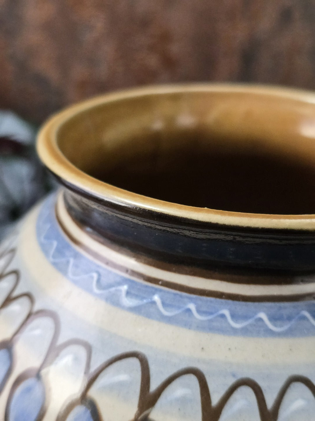 Der Rand einer Vintage Vase im Mid-Century Stil aus deutscher Keramik, cremefarbener Grundton mit blau-braunem Ornamentdekor, weißer Scherben, dekorativ für Sideboard und Regal.
