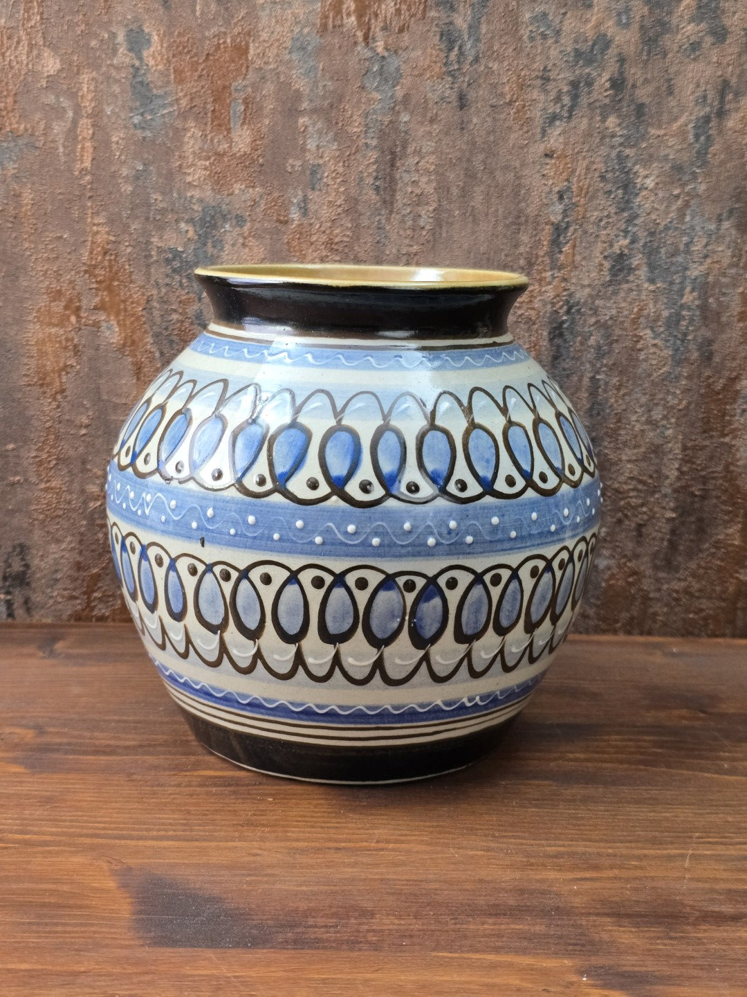 Gesamtansicht auf rotbraunem Holz stehend. Sammlerstück aus Ostdeutschland, vermutlich VEB Lausitzer Keramik Bischofswerda, blau-weiß-braune Vintage Vase mit feinem Haarriss am Standring und guter Gesamtausstrahlung.