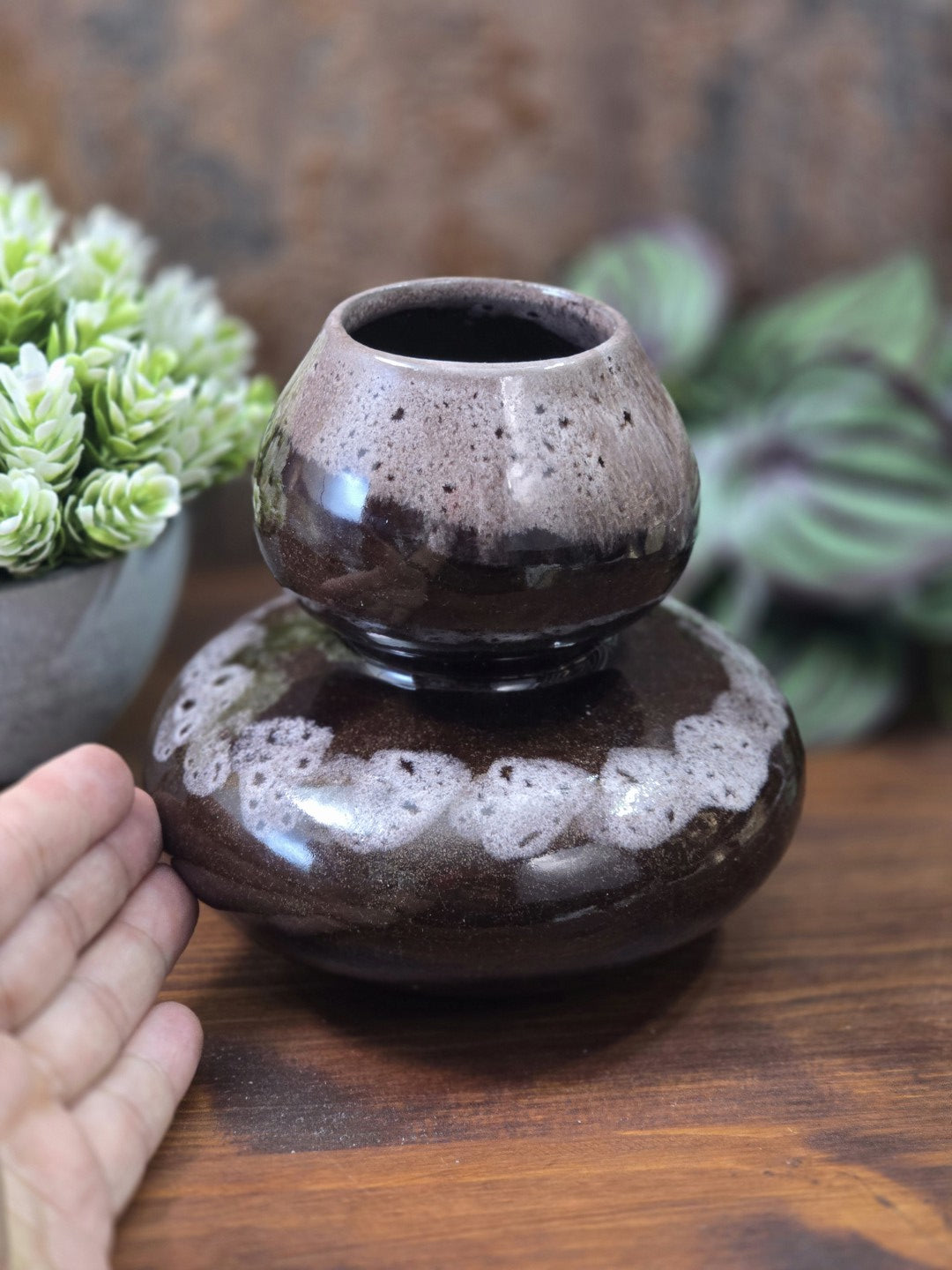 Vintage Keramikvase mit braun-beiger Verlaufsglasur und breiter Kugelform neben einer Hand zur Darstellung der Größe.