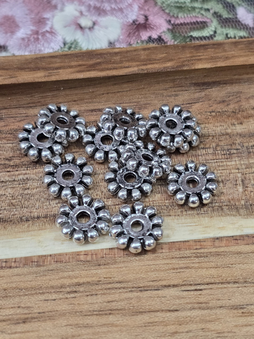 Flache Metall-Perlen in Altsilber-Optik mit geriffeltem Rand für Armbänder und Ketten.