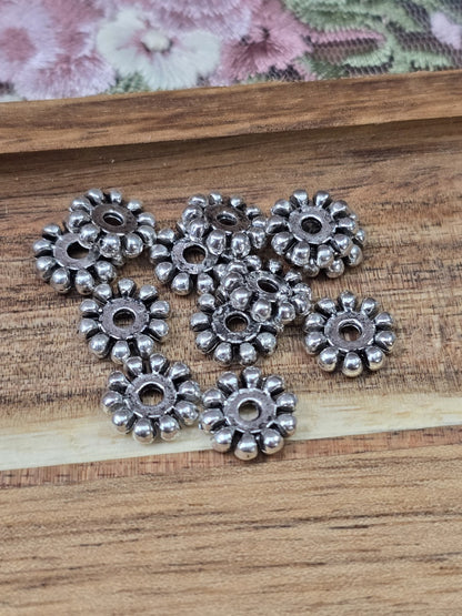Flache Metall-Perlen in Altsilber-Optik mit geriffeltem Rand für Armbänder und Ketten.