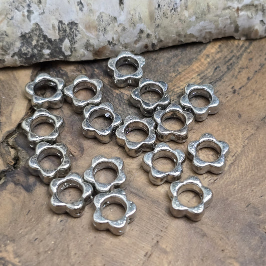 16 Metallperlen in Blumenform, Antiksilber, 8 mm. Jede Perle besticht durch ein filigranes Blumenmuster. Das längs verlaufende Fädelloch ermöglicht einfaches Aufreihen. Perfekt für Armbänder, Ketten oder andere kreative Schmuckideen. Set: 16 Stück.