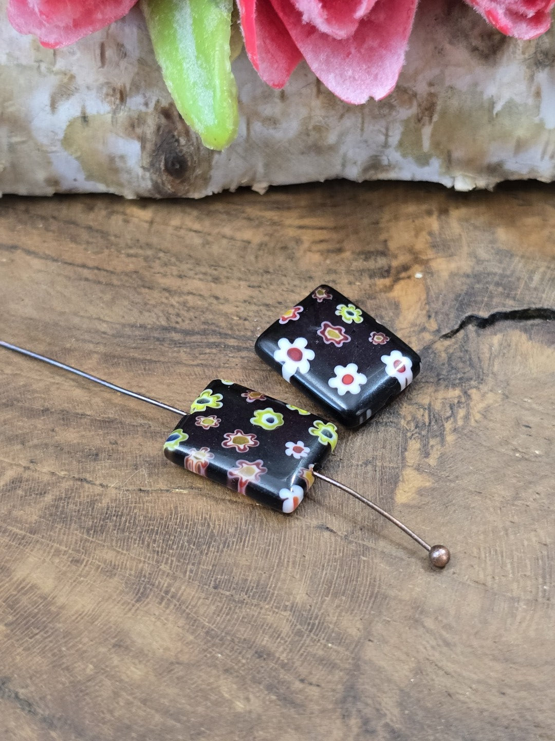 Aufgereihte rechteckige Millefiori-Blumenperle (14x10 mm) auf Schmuckdraht mit Kugelnietstift.