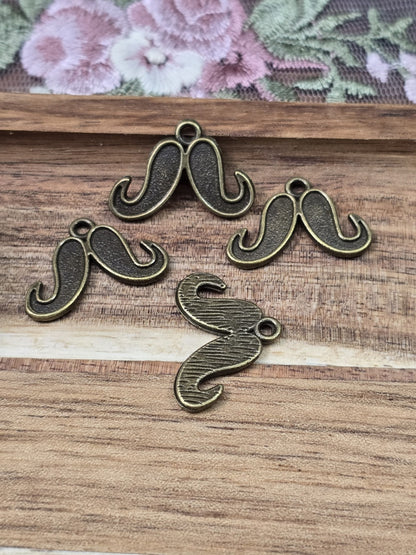 Vorder- und geriffelte Rückseite der kleinen Mustache-Anhänger im Vintage-Stil für DIY-Projekte.