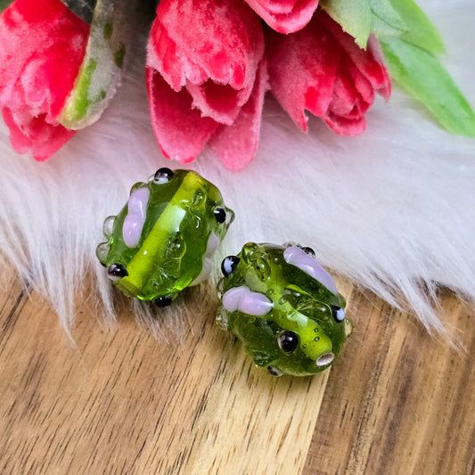 2 olivgrüne Glasperlen mit rosa & schwarzen Bumps. Handgefertigt in Indien – für auffällige DIY-Ketten, Armbänder und kreative Schmuckideen mit Struktur.