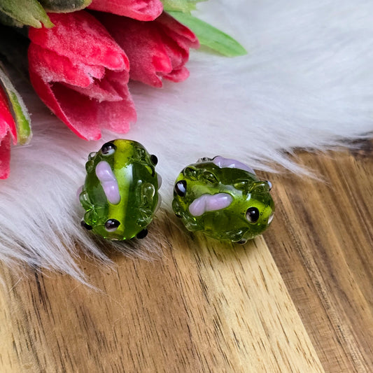 2 olivgrüne Glasperlen mit rosa & schwarzen Bumps. Handgefertigt in Indien – für auffällige DIY-Ketten, Armbänder und kreative Schmuckideen mit Struktur.