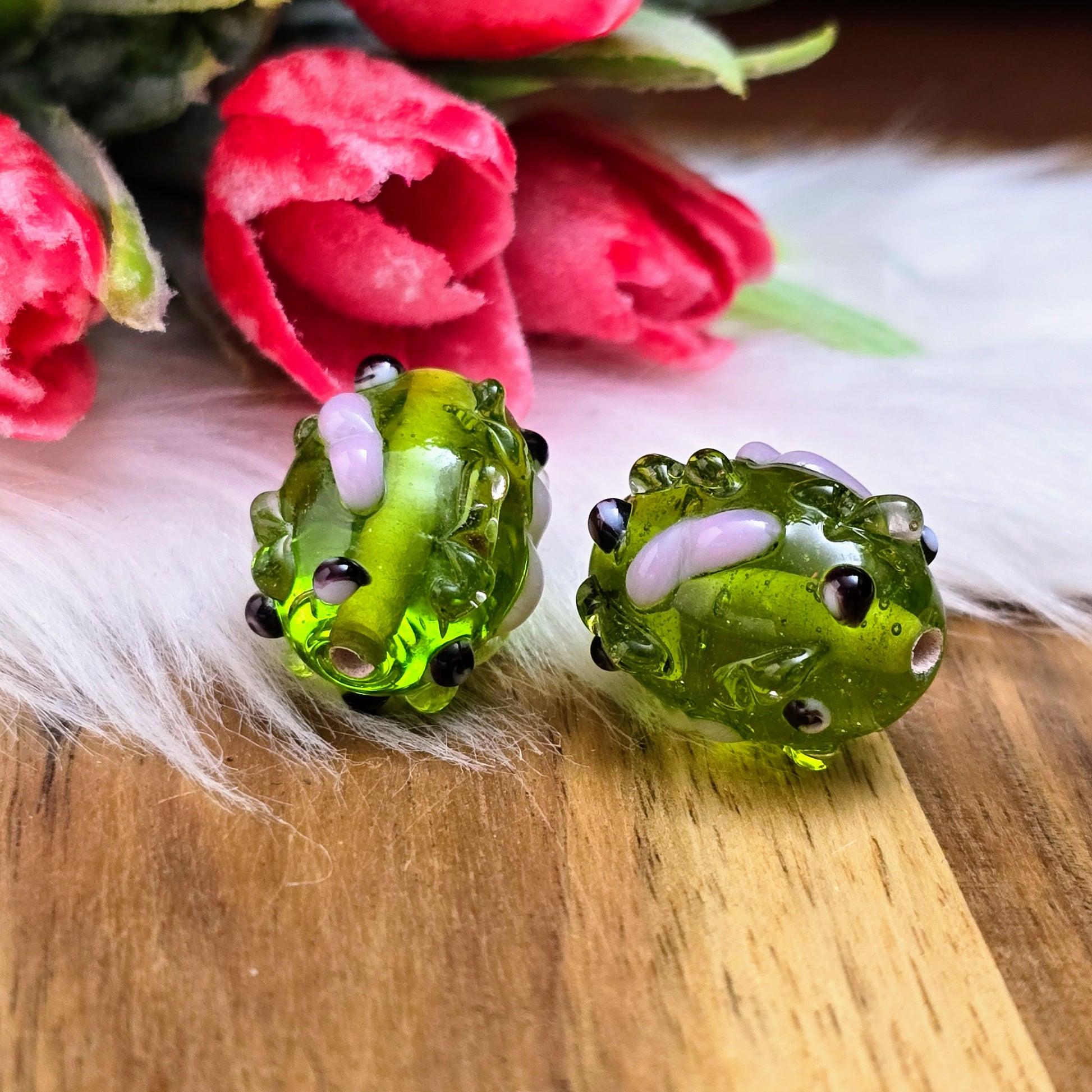 2 olivgrüne Glasperlen mit rosa & schwarzen Bumps. Handgefertigt in Indien – für auffällige DIY-Ketten, Armbänder und kreative Schmuckideen mit Struktur.