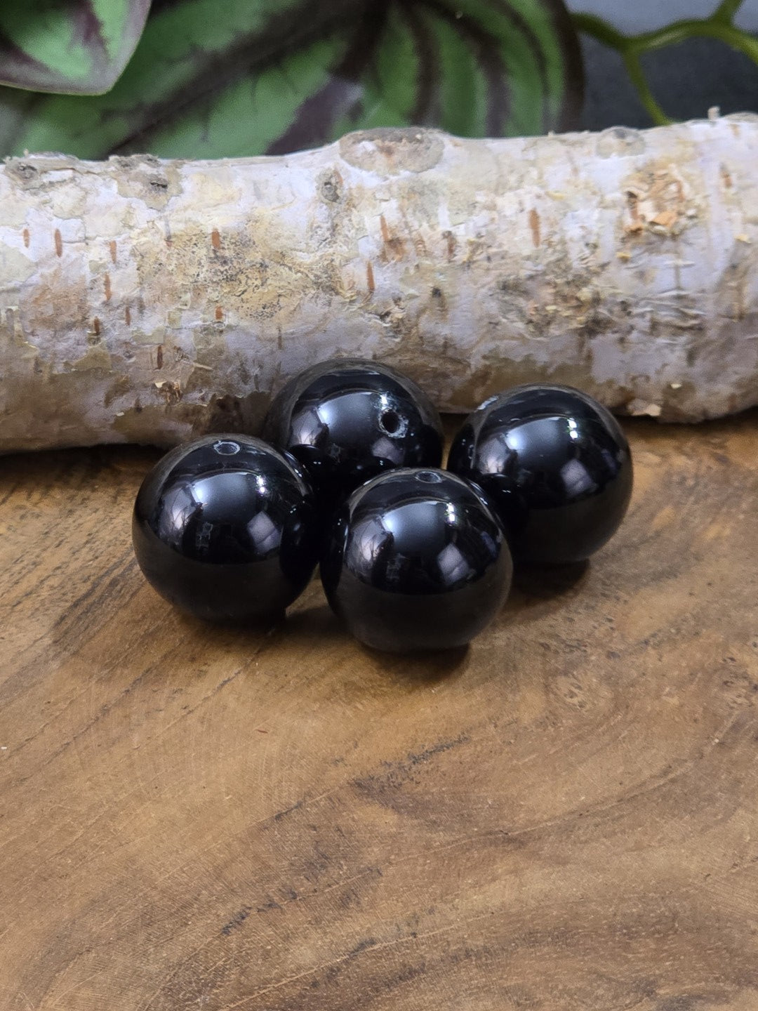 Vier schwarze Onyx-Perlen mit glänzender Oberfläche und Bohrung für DIY-Schmuck